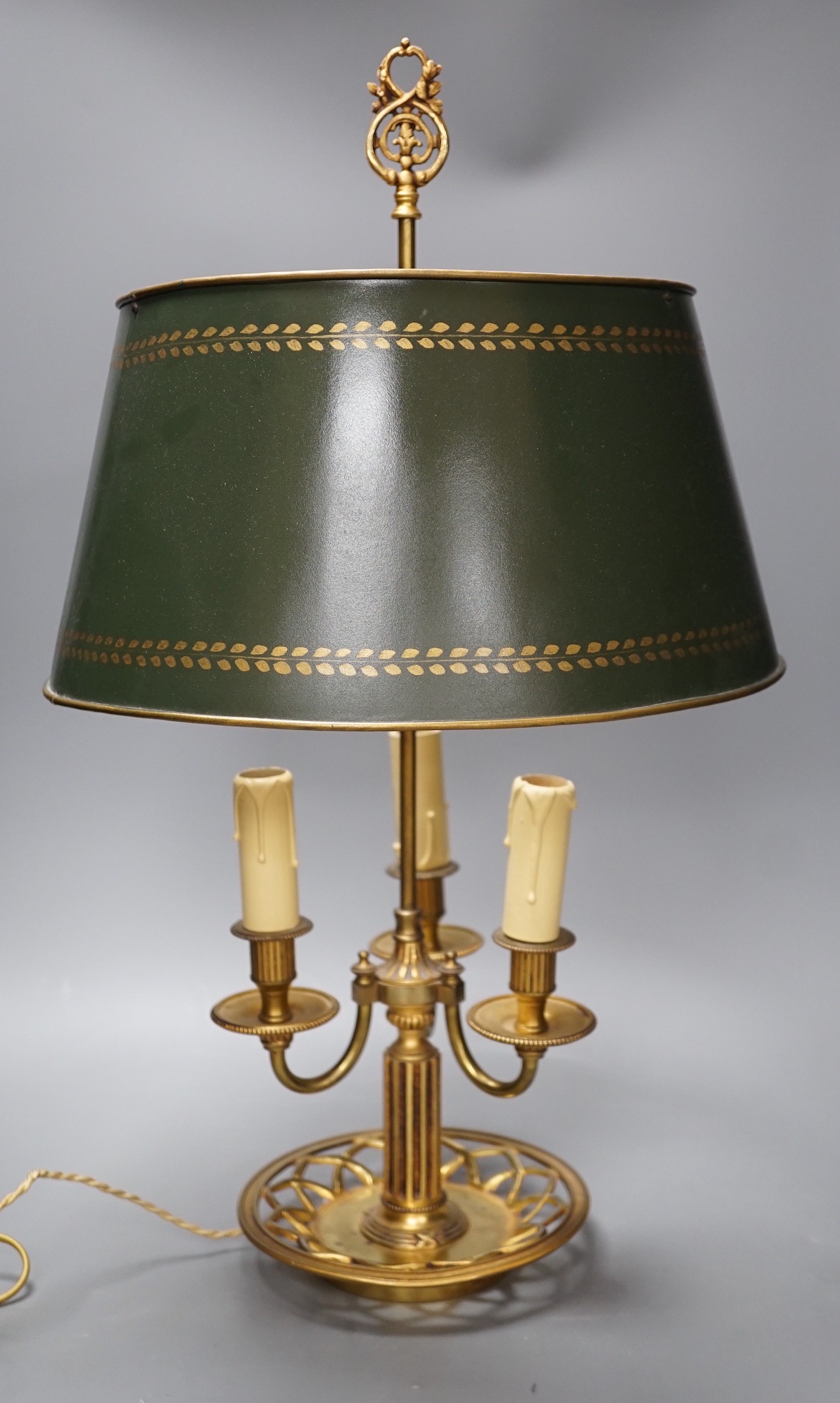 A gilt brass bouillote lamp with tole ware shade, 57 cms high